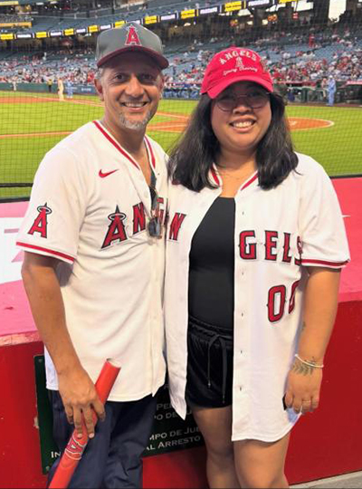 Emily and Dr. Vora at Angels Game in front of baseball field.