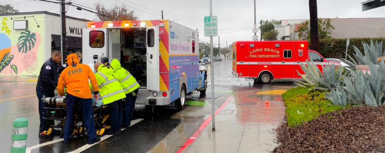 first responders loading up a patient into an ambulance-like vehicle labeled as the "Mobile Stroke Unit."