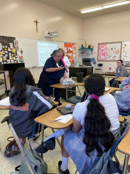 A nurse in a high school classroom teaching high schoolers about the signs of stroke.