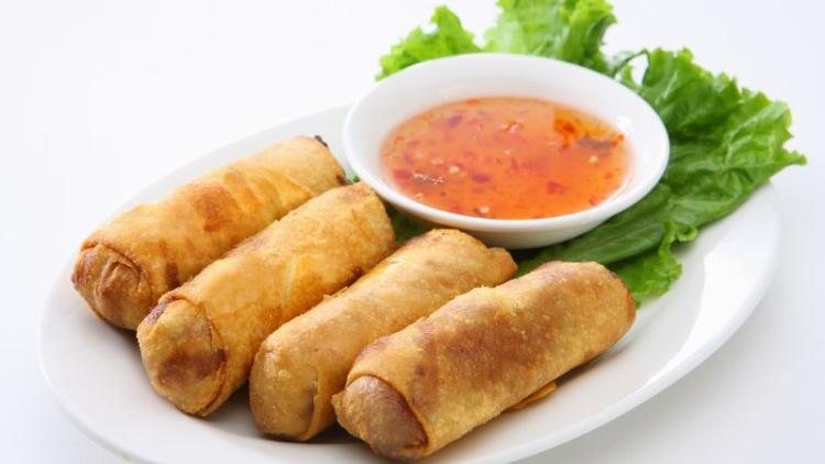 a small plate of egg rolls with some sweet and sour sauce on the side