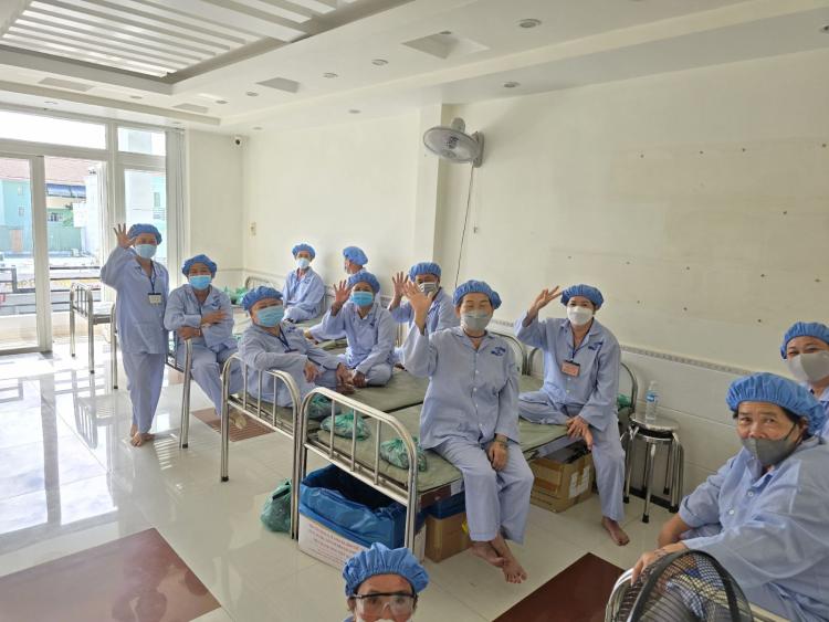 A group of eye surgery patients in the hospital gowns in the  thanking the doctors for their help in restoring their sight 
