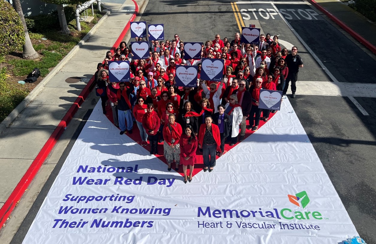 group of people standing in a heart shape.
